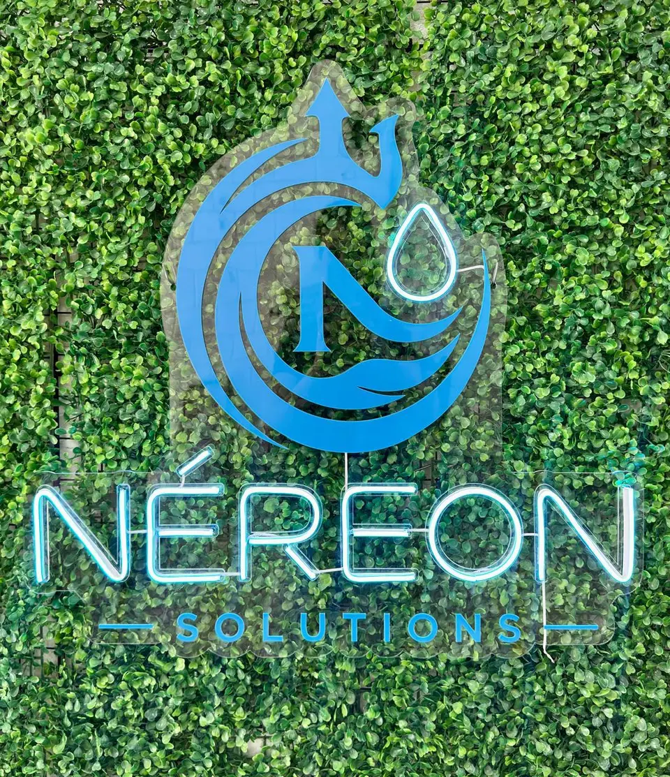 Logo da Néreon Solutions em neon LED azul sobre parede verde