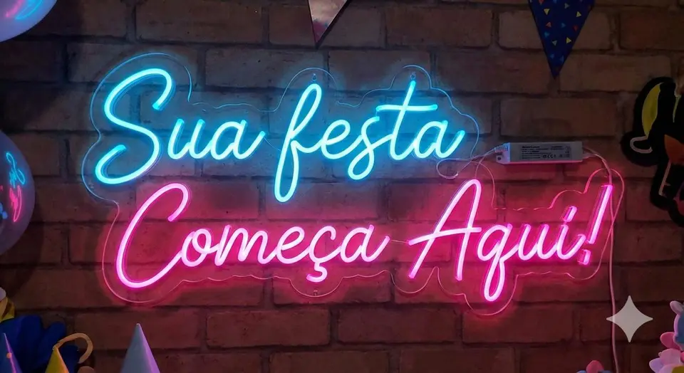 Painel neon azul e rosa "Sua festa começa aqui" em parede de tijolos