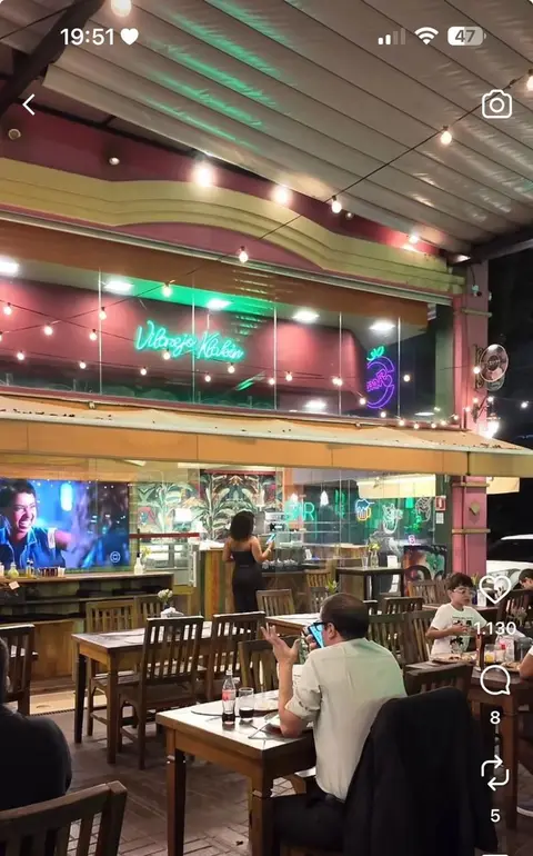 Bar com painel neon LED aceso acima do balcão